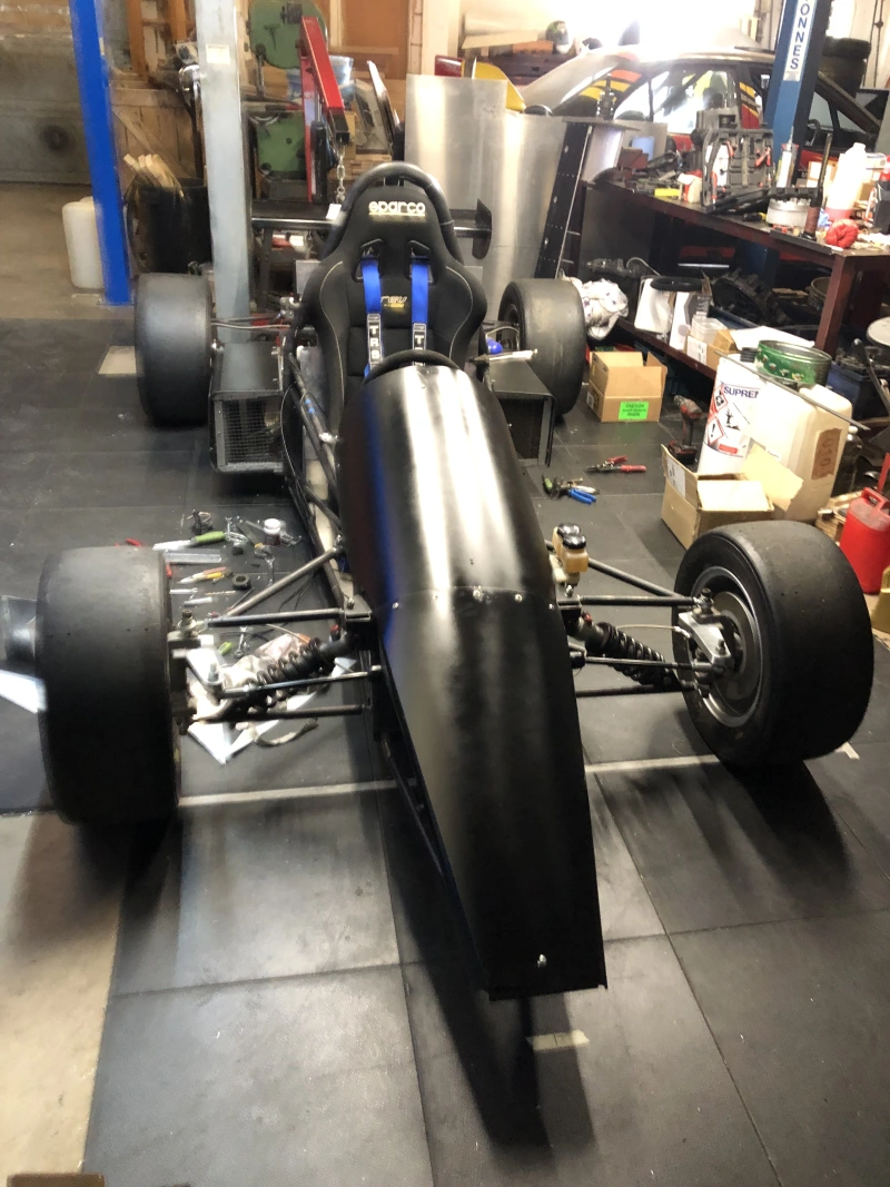 Voiture de course de côte monoplace à moteur à deux temps, équipée d'une boîte de vitesses séquentielle à 6 rapports.
