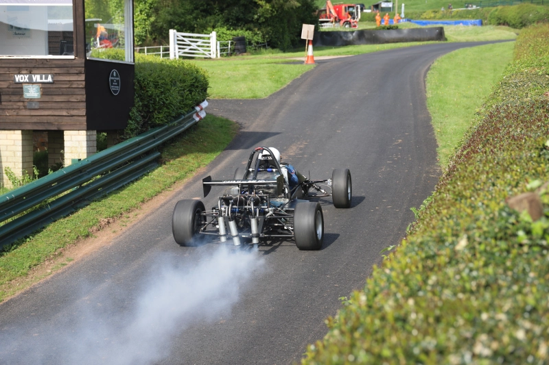 Voiture de course de côte monoplace à moteur à deux temps, équipée d'une boîte de vitesses séquentielle à 6 rapports.