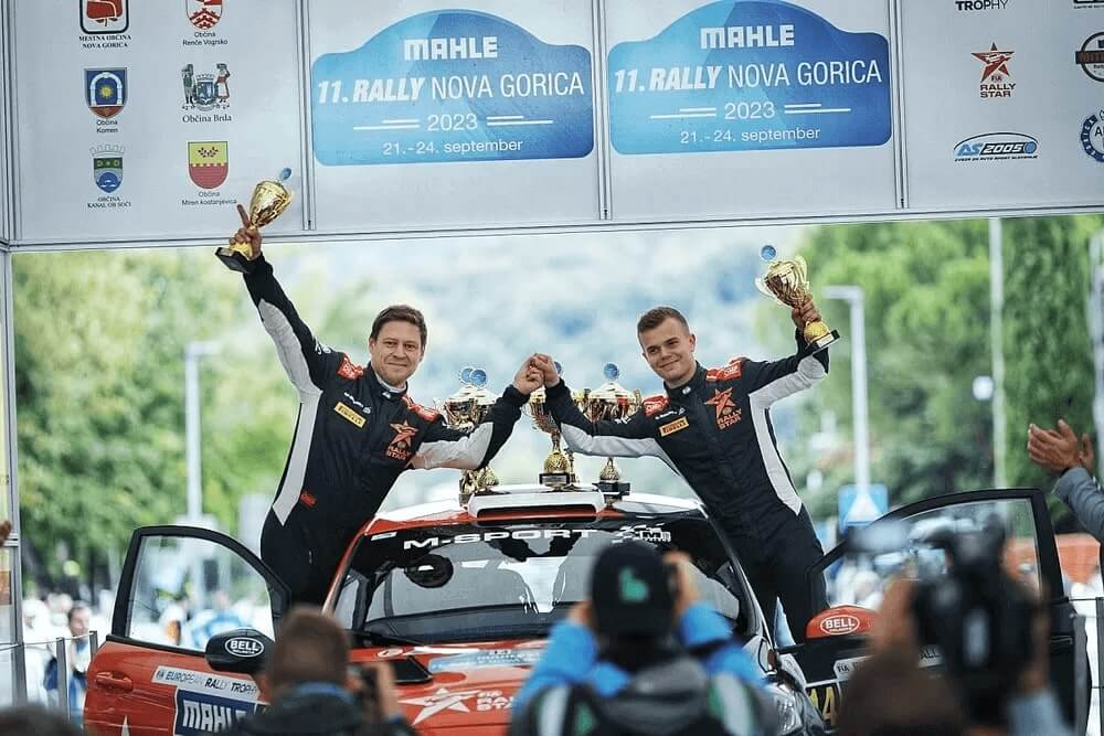 Rally driver and co-driver on the podium