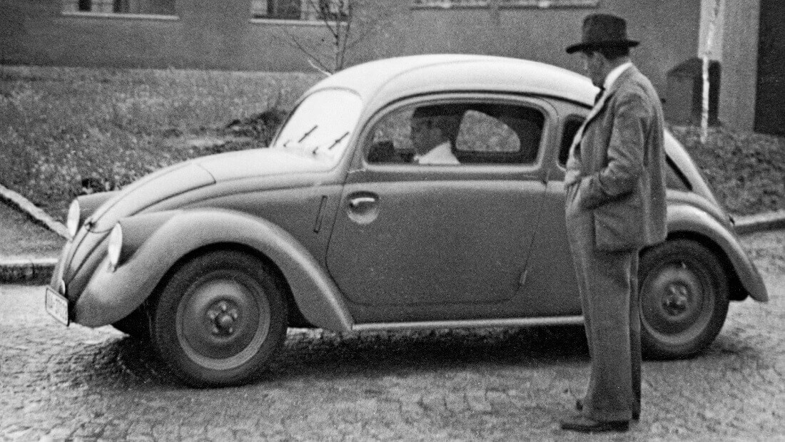 Ferdinand Porsche in front of a Volkswagen Beetle prototype